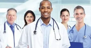 Três médicos de jaleco branco e estetoscópio sorrindo lado a lado, imagem ilustrativa