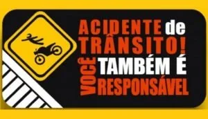 Placa de alerta de motocicleta ao lado do texto 'Acidentes de trânsito você também é responsável'