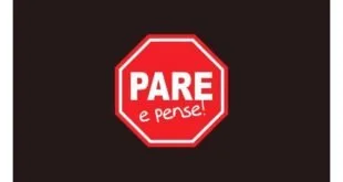 Placa vermelha de pare com os dizeres 'Pare e pense!' sobre fundo escuro