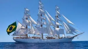 Navio veleiro de três mastros com todas as velas brancas abertas navegando em mar aberto