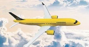 Avião de carenagem amarela em voo acima das nuvens com o nome Itapemirim na fuselagem