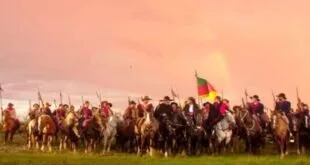 Pintura de carga de cavalaria com soldados a cavalo e bandeira erguida sob céu alaranjado