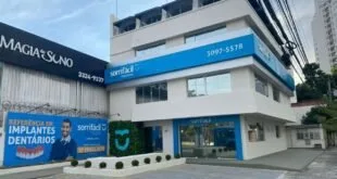 Fachada de clínica odontológica em azul e branco com o letreiro 'Sorrifácil' e telefone