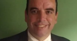 Retrato de homem sorridente de terno e gravata sobre fundo verde