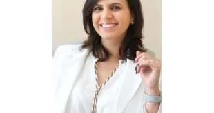 Retrato de mulher sorridente de blazer branco sobre fundo claro