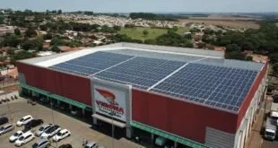 Vista aérea de supermercado com telhado coberto por placas solares e estacionamento