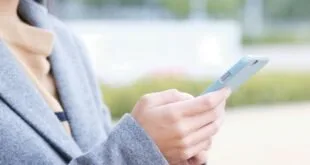 Mãos segurando celular ao ar livre, imagem ilustrativa sobre uso de aplicativos