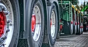 Close de rodas e pneus de caminhões enfileirados lado a lado