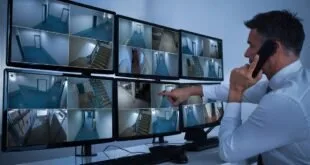 Pessoa aponta para painel de telas de monitoramento por câmeras de segurança
