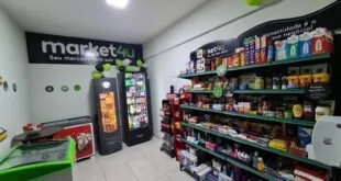 Interior de mercado autônomo com prateleiras de produtos e geladeiras de bebidas