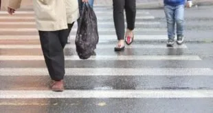 Pedestres atravessando uma faixa de pedestres, vistos da cintura para baixo