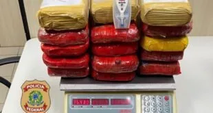Tabletes embalados em vermelho e amarelo empilhados sobre uma balança digital