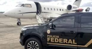 Viatura da Polícia Federal estacionada ao lado de um jato executivo em pista de aeroporto