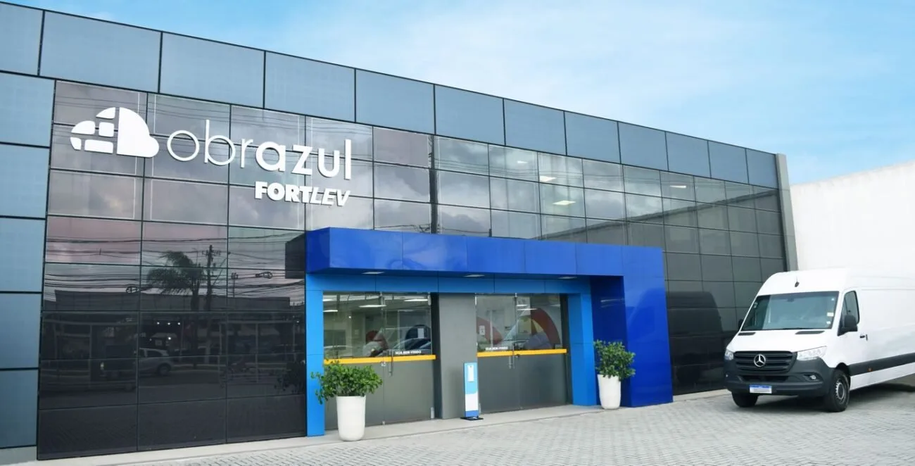 Fachada de loja em azul e branco com letreiro e portas de vidro na entrada