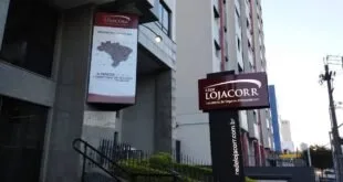 Banners da Rede Lojacorr na entrada de um edifício em dia nublado