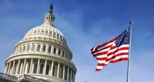Cúpula do Capitólio dos Estados Unidos ao lado da bandeira americana em céu azul