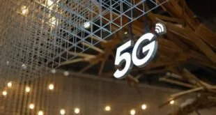 Letreiro luminoso com o símbolo '5G' pendurado no teto de um pavilhão