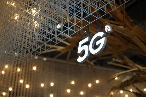 Letreiro luminoso com o símbolo '5G' pendurado no teto de um pavilhão