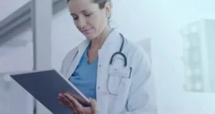 Médica de jaleco branco e estetoscópio usa um tablet, imagem ilustrativa sobre saúde digital