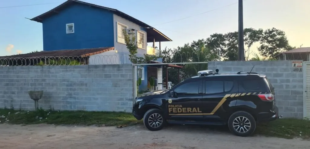 Viatura da Polícia Federal parada em frente a um sobrado durante operação