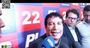 Homem dá entrevista a microfones diante de painel com o número 22 e a sigla PL