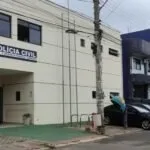 Fachada de prédio com a inscrição Polícia Civil na parede e carro estacionado na rua