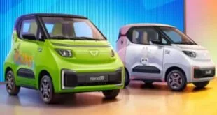 Dois carros elétricos compactos, um verde e outro branco, expostos lado a lado em estúdio