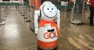 Robô branco e laranja com a marca Gol parado no saguão de um aeroporto