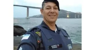Policial militar fardado em selfie com ponte sobre o mar ao fundo