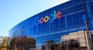 Prédio envidraçado com o logotipo colorido do Google na fachada, visto de baixo