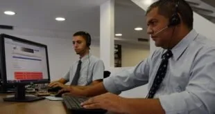 Dois homens de camisa e gravata trabalham em computadores, imagem ilustrativa sobre emprego