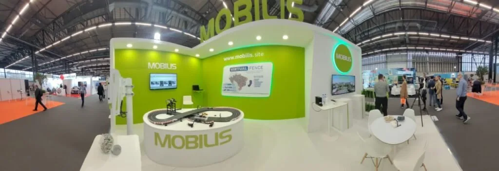 Estande verde de feira com a marca Mobilis e produtos expostos em balcão