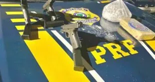 Armas, carregadores e tabletes de droga sobre capô de viatura com a inscrição PRF