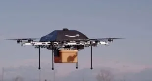 Drone de entrega da Amazon voando com caixa de papelão presa sob a estrutura