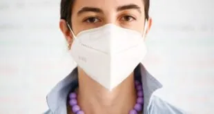 Pessoa usando máscara branca tipo PFF2 cobrindo boca e nariz, imagem ilustrativa