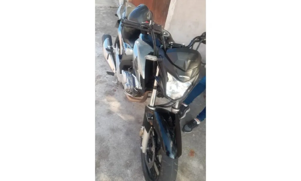 Motocicletas escuras estacionadas lado a lado em área de piso de cimento