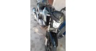 Motocicletas escuras estacionadas lado a lado em área de piso de cimento