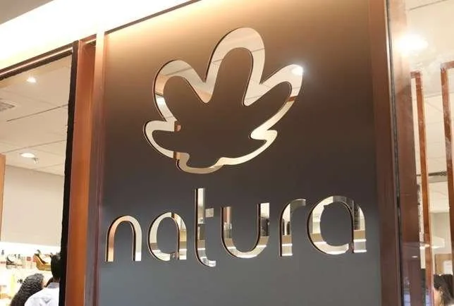 Logotipo da Natura em relevo sobre painel de parede iluminado