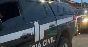 Viatura com o letreiro 'Polícia Civil' parada em rua estreita à noite