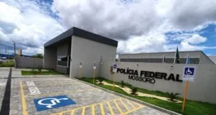 Fachada de prédio com letreiro 'Polícia Federal Mossoró' e vagas de estacionamento em frente