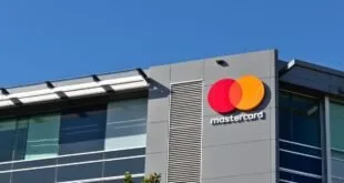 Logotipo da Mastercard na fachada de prédio corporativo sob céu azul