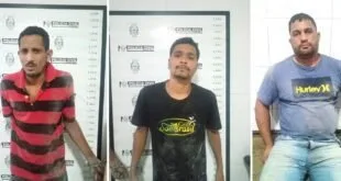 Três homens algemados diante de painel de identificação com escala de altura da Polícia Civil