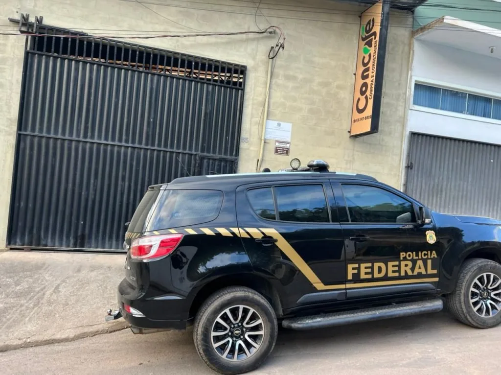 Viatura preta da Polícia Federal estacionada em frente a um estabelecimento fechado
