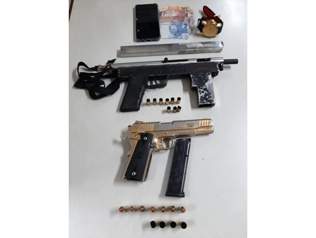 Armas de fogo, munições e objetos apreendidos dispostos sobre uma mesa