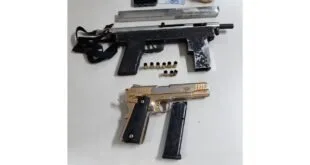 Armas de fogo, munições e objetos apreendidos dispostos sobre uma mesa