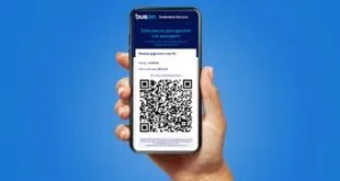 Mão segurando celular com aplicativo de passagem de ônibus e QR code na tela