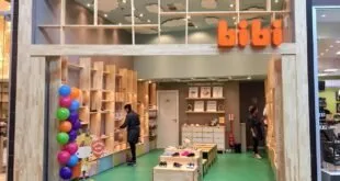 Fachada de loja de calçados em shopping com balões coloridos na entrada
