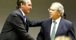 Dois homens de terno apertando as mãos em evento oficial, imagem ilustrativa sobre economia
