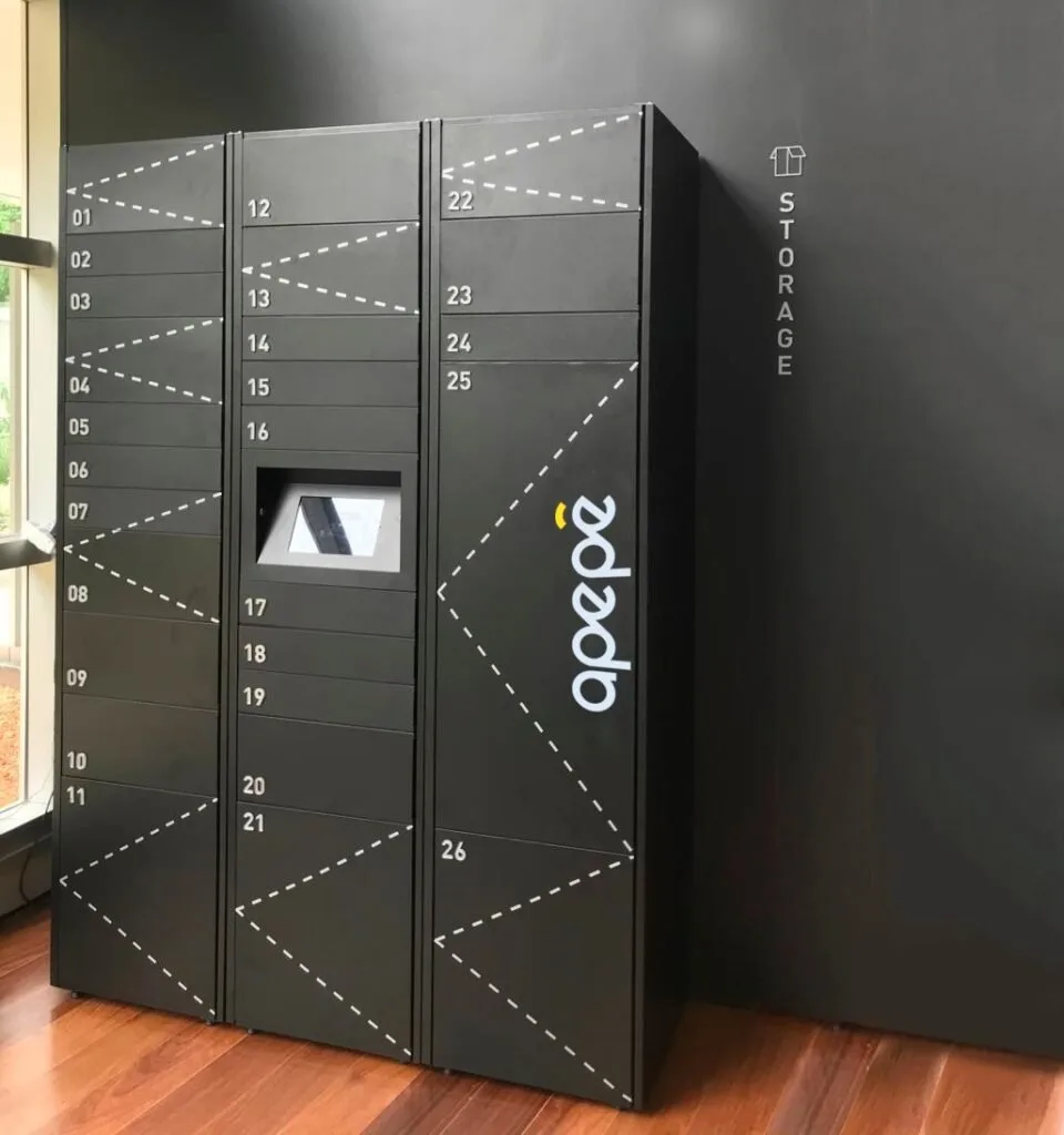 Armário inteligente preto com compartimentos numerados instalado em hall de prédio