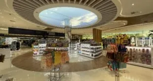 Loja de conveniência sob teto circular iluminado no saguão de um terminal